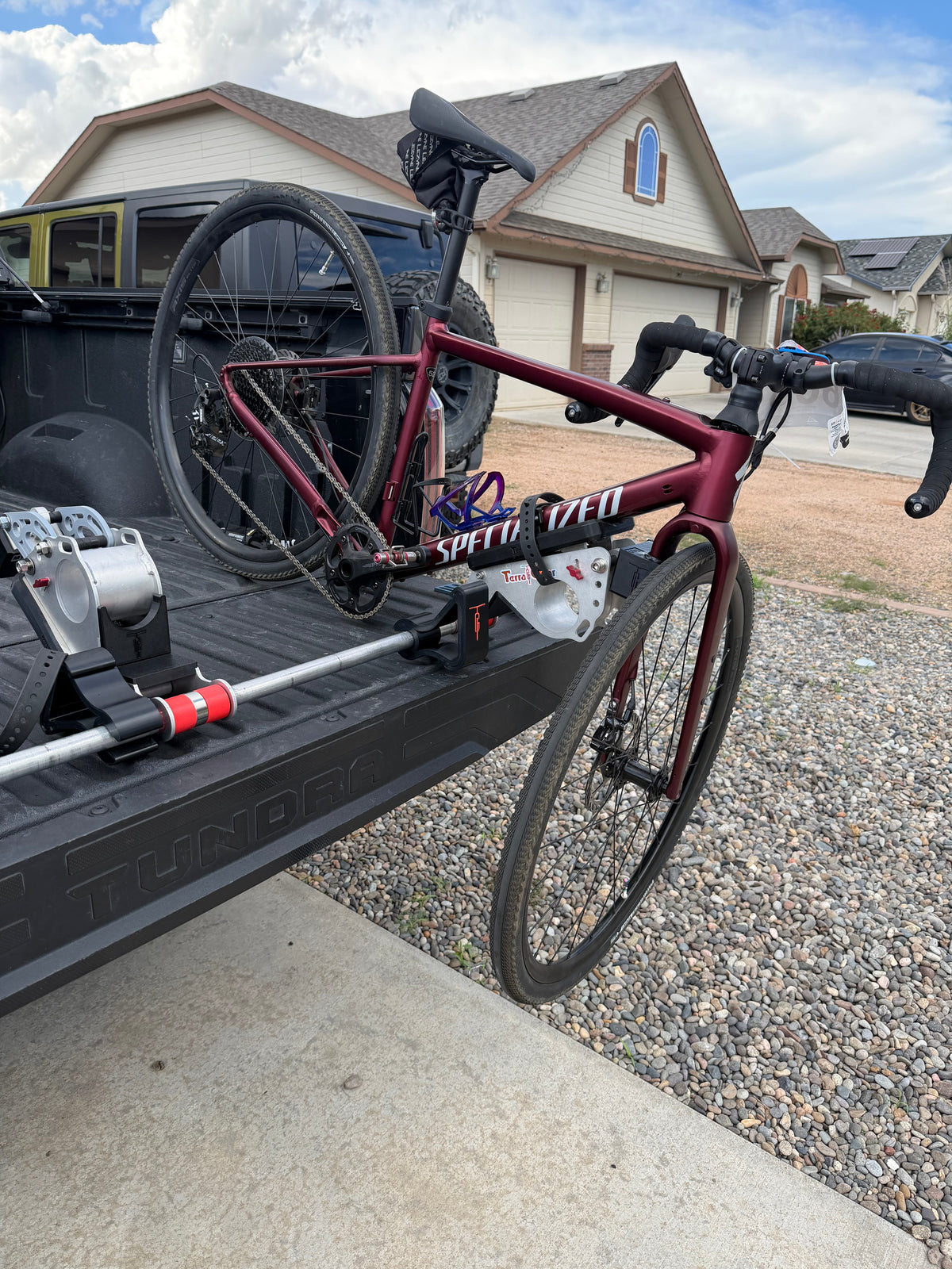 A gravel bike loaded onto a TerraGnar articulating tailgate rack on a truck tailgate